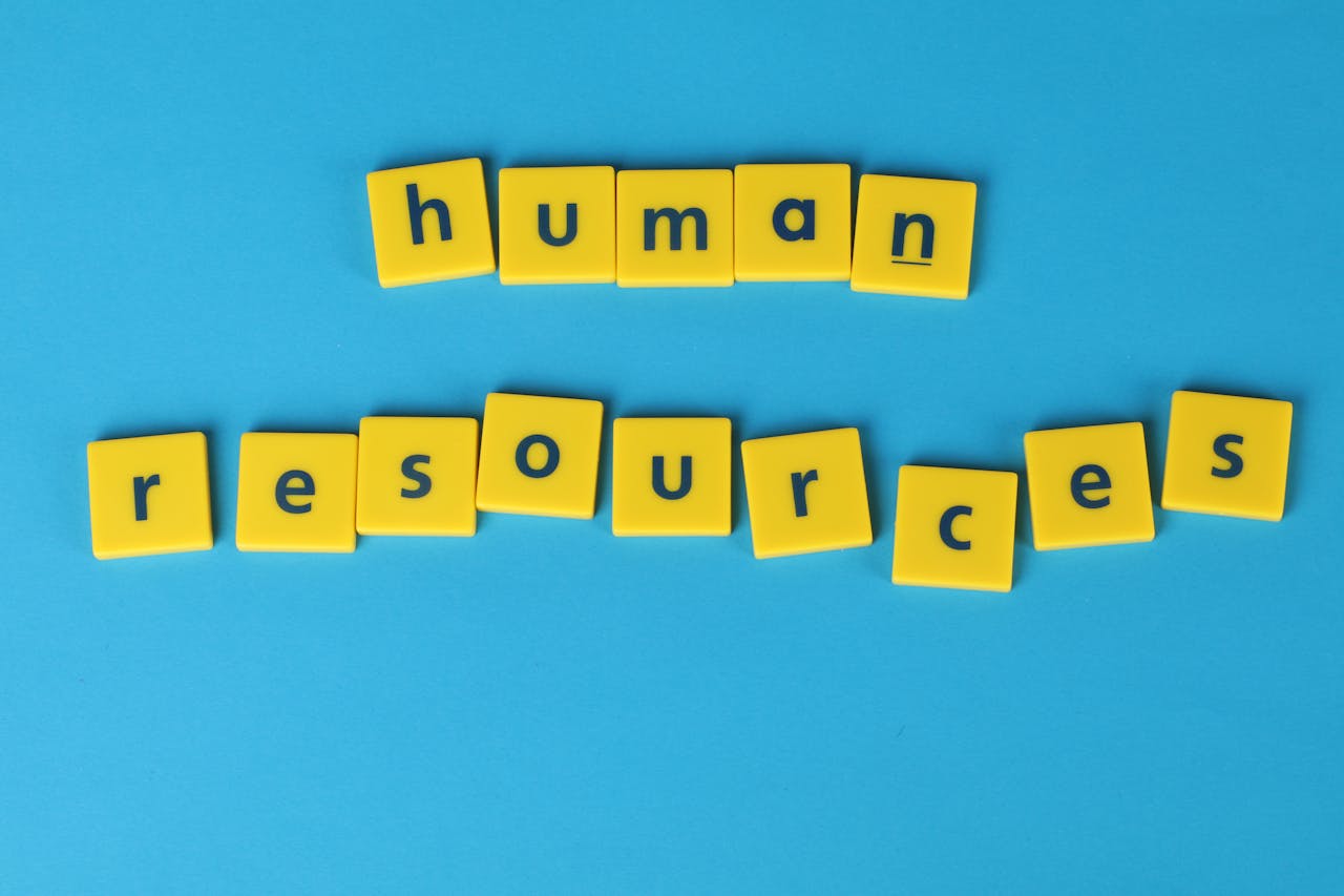 Yellow tiles spelling human resources on a blue background, ideal for HR or business concepts.